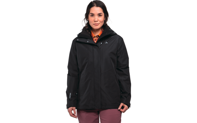 Person standing facing the camera, wearing a black hooded jacket, orange patterned neck scarf, pink pants; hands at sides; white background