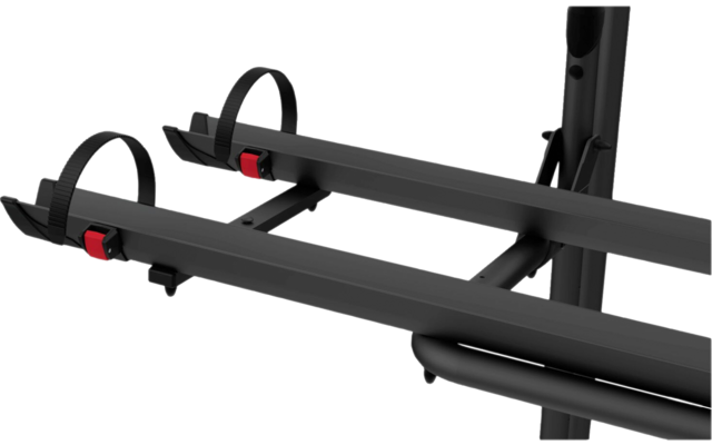 Schwarzer Fahrradträger mit zwei parallelen Schienen und zwei Radsicherungsbändern mit roten Verschlüssen