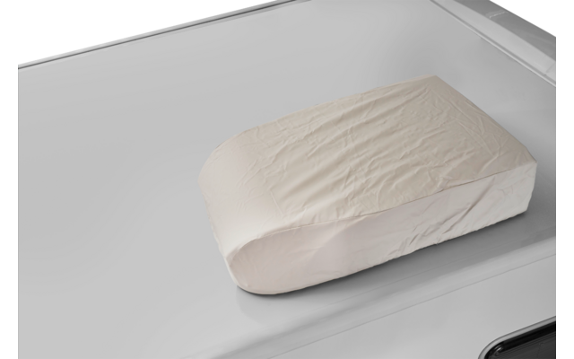 Funda rectangular de tela beige claro con arrugas sobre una superficie brillante gris plateada