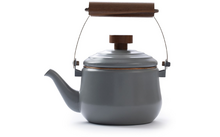 Grauer Teekessel mit braunem Holzgriff auf weißem Hintergrund