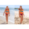 Junges Mädchen mit orangefarbener Rettungsweste und roter Badebekleidung läuft am Sandstrand, Meer im Hintergrund