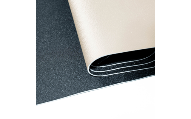 Feuille beige texturée enroulée sur une surface noire texturée, fond blanc