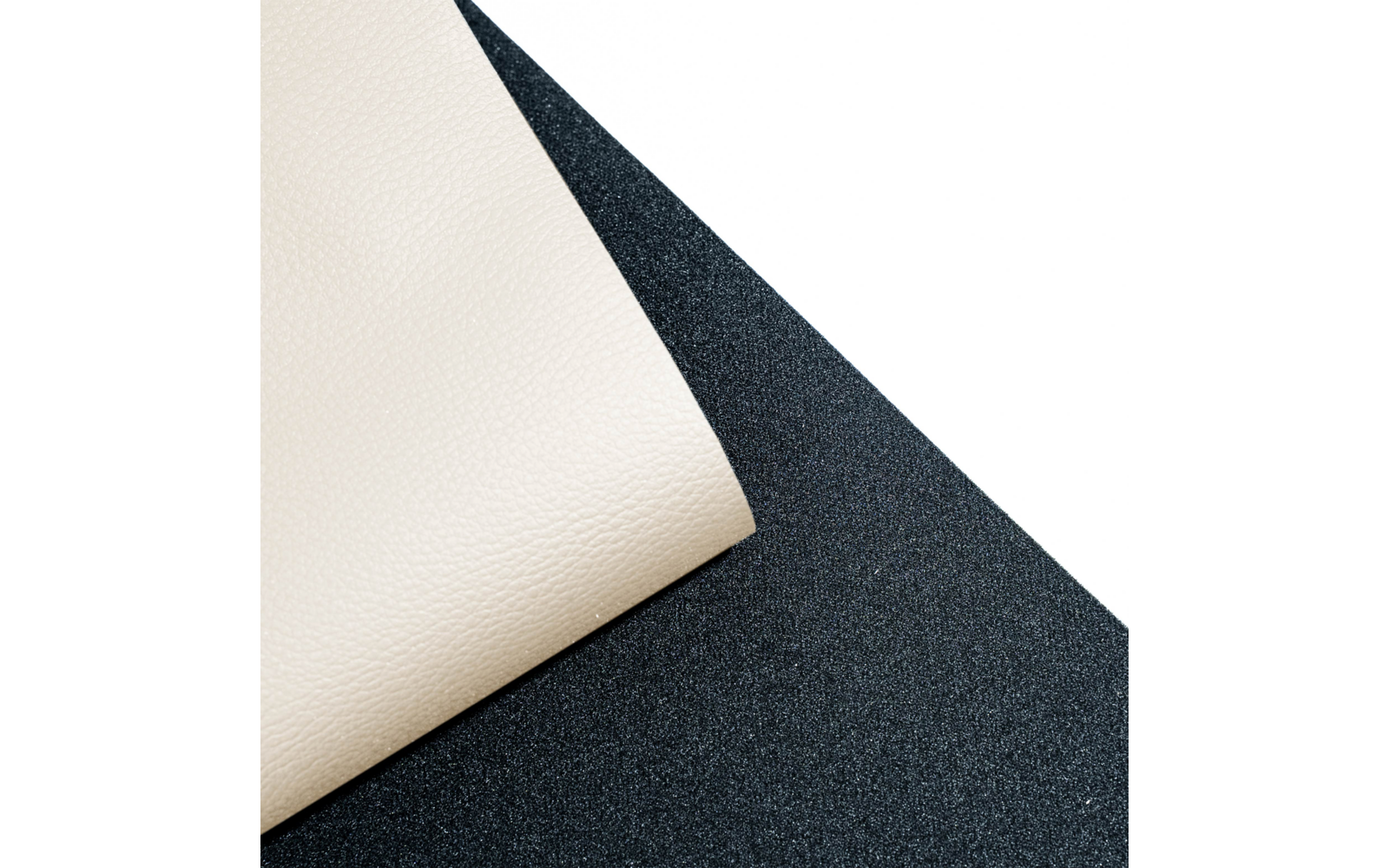 Feuille beige texturée avec coin plié sur surface noire granuleuse, zone blanche en haut à droite