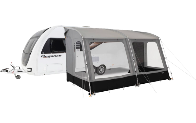 White caravan with attached gray awning with transparent windows, black lower skirt, guy lines and visible text "Elegance"