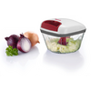 Petit hachoir de cuisine avec couvercle blanc et rouge et récipient transparent contenant des morceaux verts hachés ; à côté, un oignon rouge coupé en deux, un oignon brun entier et un brin de persil