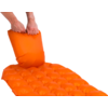 Een hand legt een opblaasbaar kussen op een oranje luchtbed