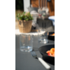 Een gedekte tafel met een glas wijn, bestek en een bord met eten in een restaurant