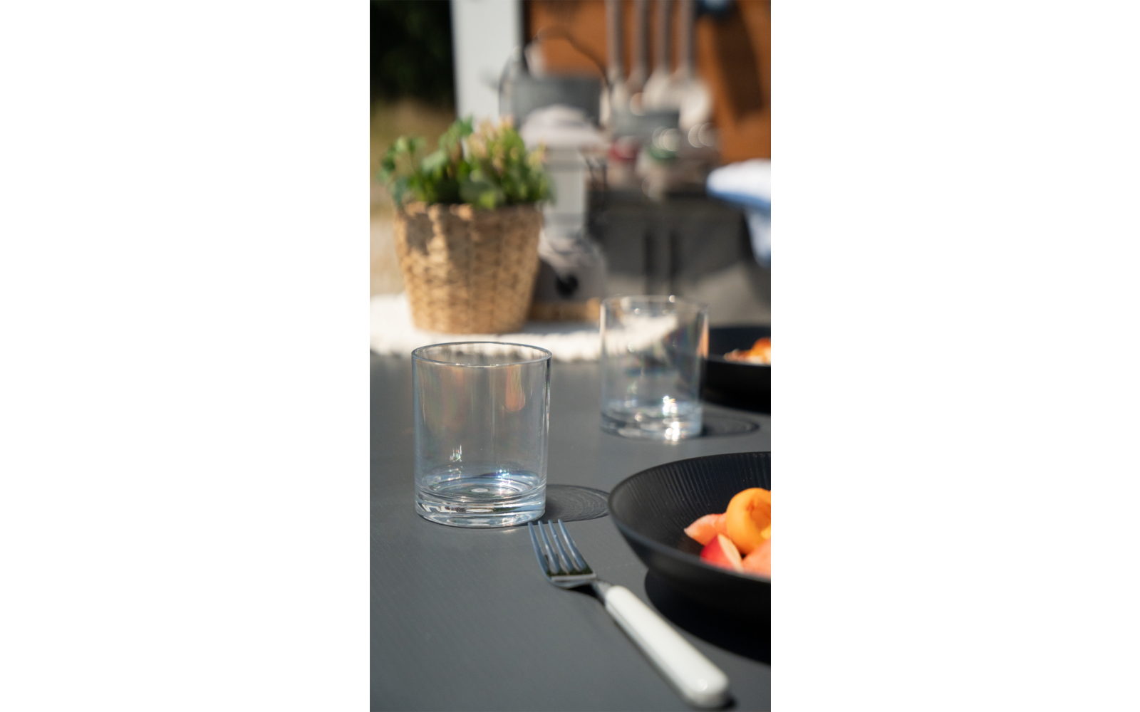 Een gedekte tafel met een glas wijn, bestek en een bord met eten in een restaurant