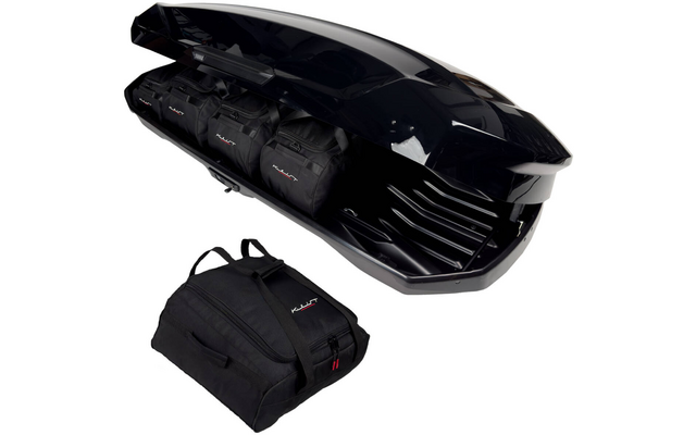 Coffre de toit noir ouvert contenant trois sacs de voyage noirs et un sac de voyage noir supplémentaire à côté sur fond blanc