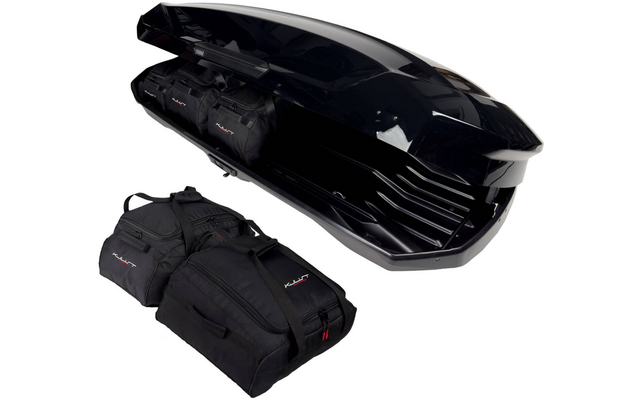 Coffre de toit noir ouvert avec trois sacs de voyage noirs sur fond blanc