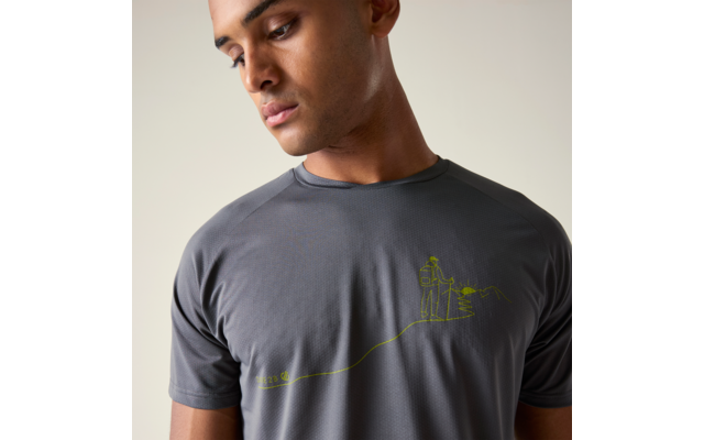 Mann im grauen T-Shirt mit kurzem Ärmel, Blick nach unten; T-Shirt mit gelbgrüner Liniengrafik einer Person mit Rucksack und einem Berg