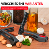 Plusieurs presses à ail noires sur une surface en bois, avec des gousses et têtes d'ail, des noix et du persil au premier plan; en arrière-plan une bouteille d'huile avec des tranches d'ail, un bocal de grains de café, un bol de salade et un gant de cuisine rose; en haut le texte 'VERSCHIEDENE VARIANTEN' et la bannière rouge 'ENTDECKE QUALITÄT VON WESTMARK'