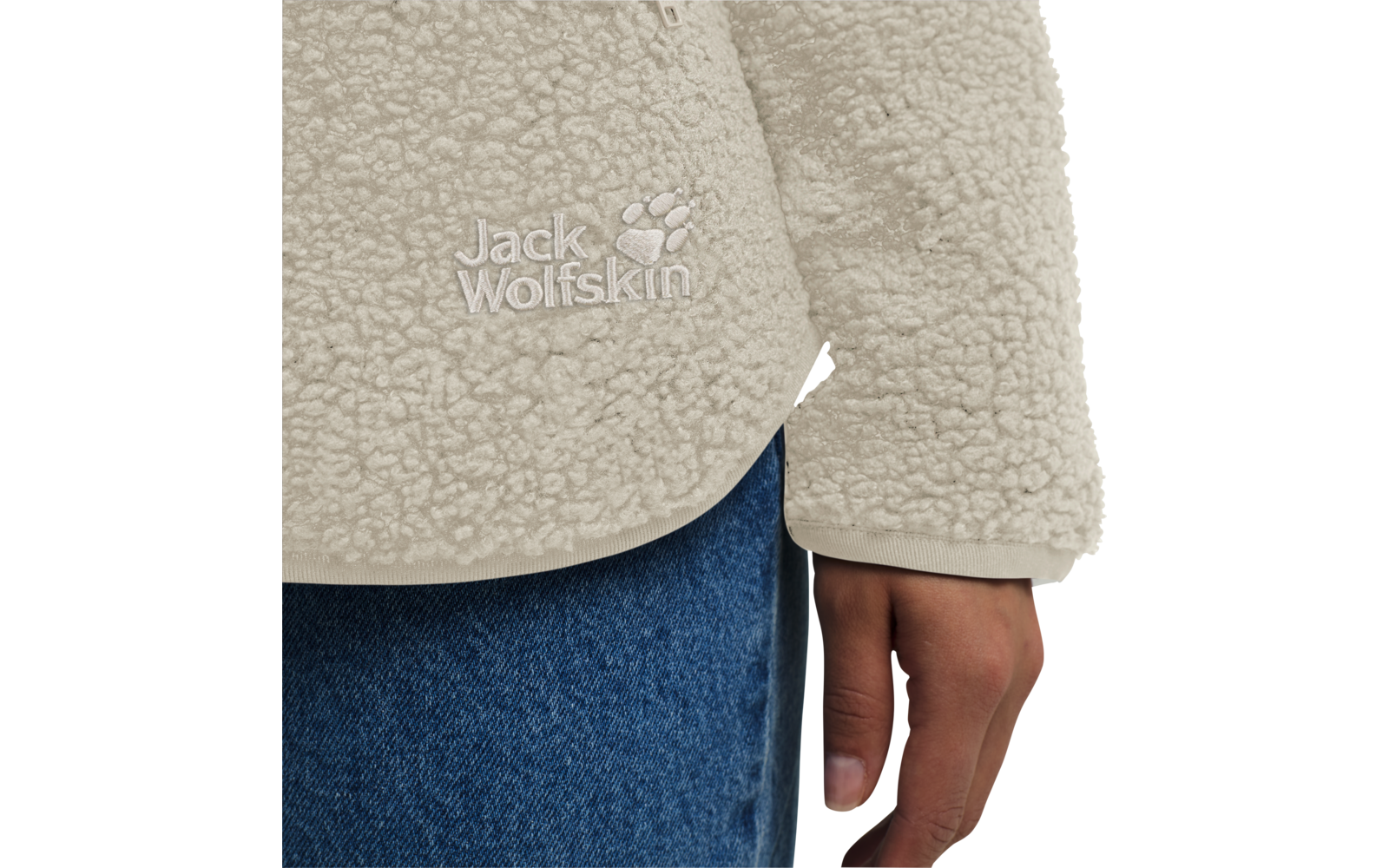Nahaufnahme von einem hellen Fleecepullover und einer Hand an der Seite