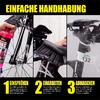 Eine Hand sprüht Schmieröl auf die Kette eines Fahrrads mit Werkzeug und Helm im Hintergrund