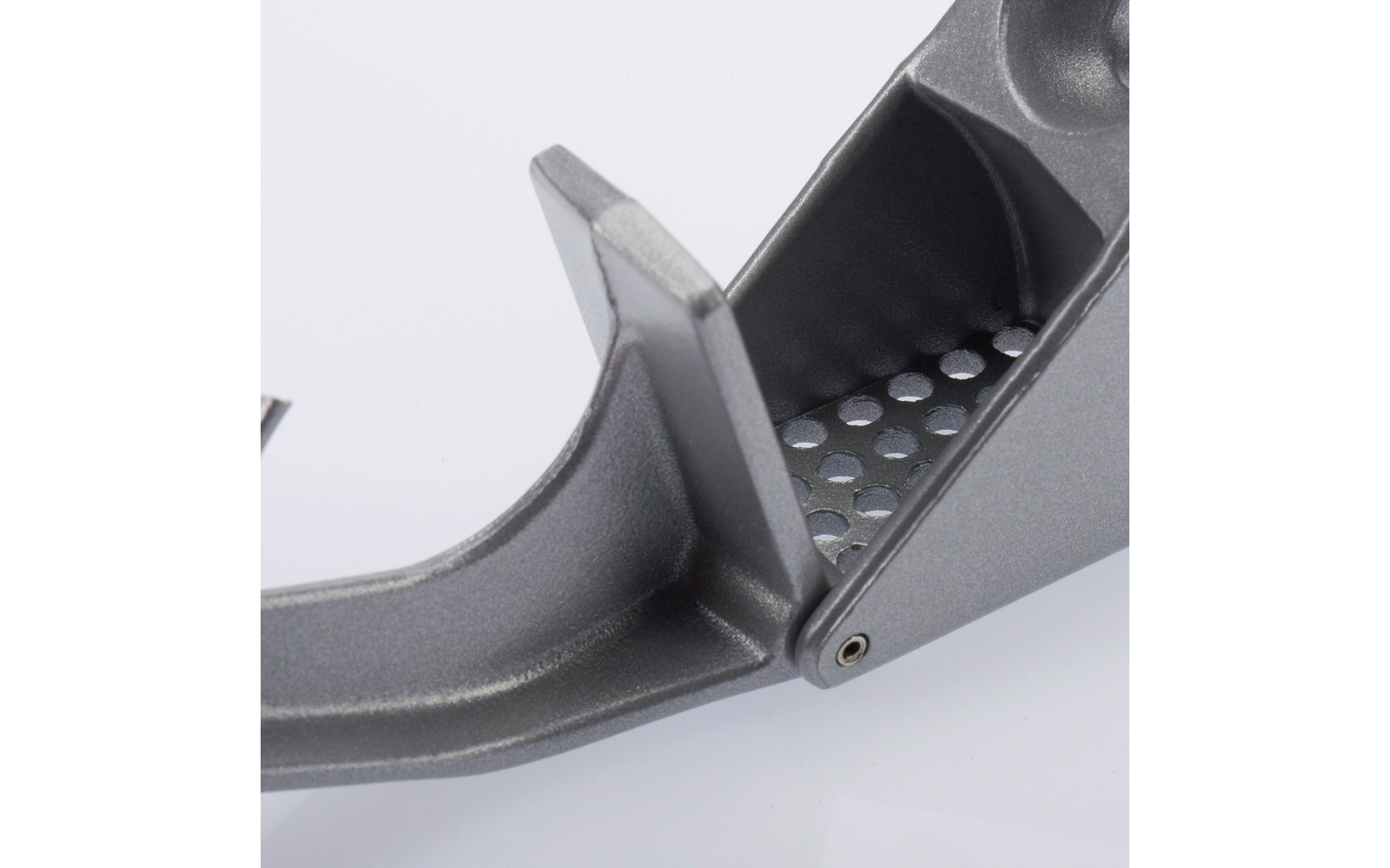 Grijs metalen object met twee hefbomen en een scharnier; één zijde heeft een geperforeerde kamer