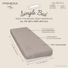 Beige hoeslaken op matras met zichtbare teksten en pijlen: 'Single Bed', 'Mako-Feinjersey-Spannbetttuch ca. 70-90 x 190-210 cm', pijlen 'ca. 70-90 cm' en 'ca. 190-210 cm', labels 'Für Matratzen von 8 bis 15 cm Matratztenhöhe', 'Mit Rundumgummispannung', '100% Baumwolle', merklogo 'PRIMERA TRAVEL', tekst 'sleep like home' met bus- en huispictogram en 'KI-generiertes Bild'