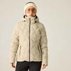 Person vor hellem Hintergrund, weiße Strickmütze, orangegetönte Brille, beige gesteppte Jacke mit Kapuze und Reißverschluss, schwarze Hose