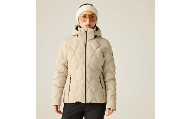 Person vor hellem Hintergrund, weiße Strickmütze, orangegetönte Brille, beige gesteppte Jacke mit Kapuze und Reißverschluss, schwarze Hose