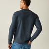 Persoon van achteren, draagt donker shirt met lange mouwen en blauwe spijkerbroek, linkerhand in achterzak, neutrale lichte achtergrond