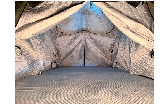 Intérieur d'une tente avec doublure matelassée argentée, entrée triangulaire ouverte, couture centrale et sol matelassé