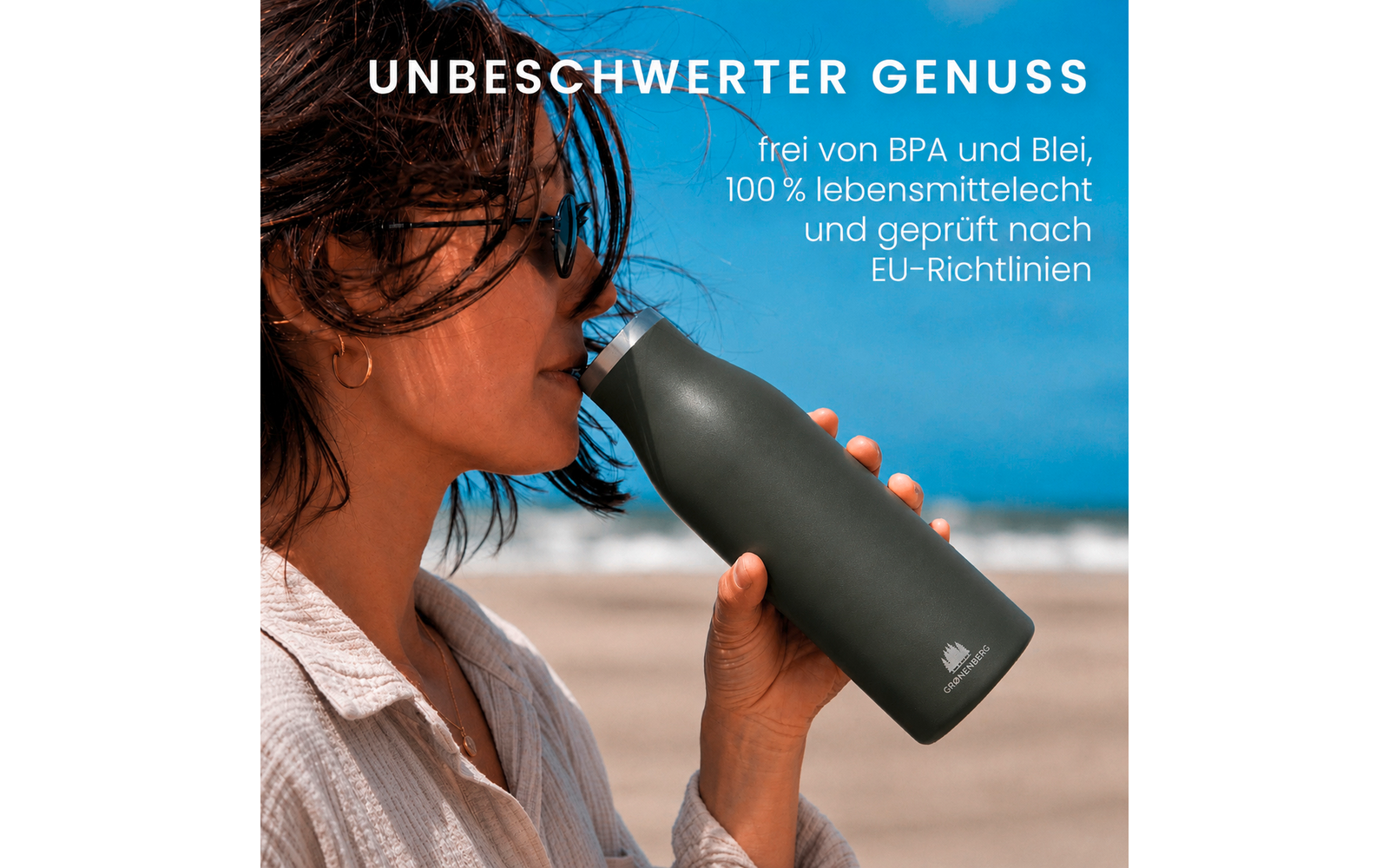 Frau im Profil trinkt aus dunkelgrüner Flasche am Strand; blauer Himmel und Meer im Hintergrund