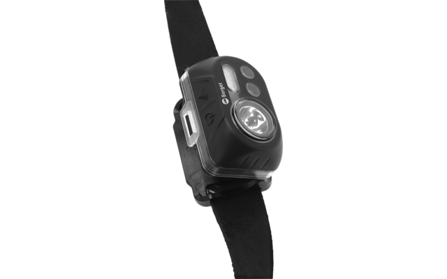 Schwarzes Kunststoffgerät an schwarzem Textilgurt, mit klarer runder Linse, drei runden Tasten, seitlichem rechteckigen Anschluss und Metallclip