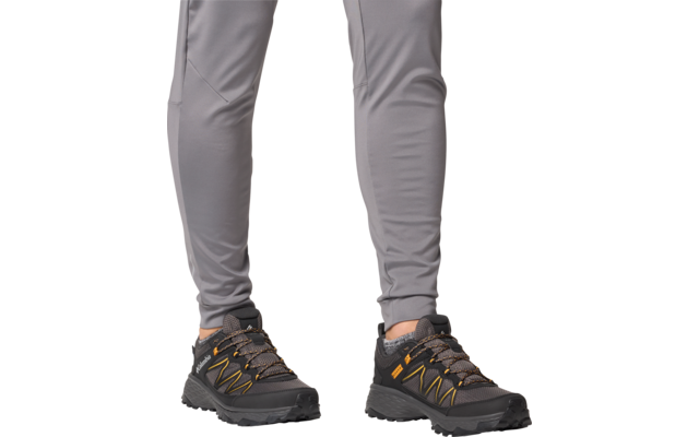 Jambes en pantalon gris et chaussures de randonnée noires