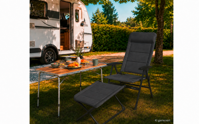Weißes Wohnmobil auf Rasen, davor ein Campingtisch mit Schalen, Brot und einem Kürbis, daneben ein dunkelgrauer Klappsessel mit Fußteil, Bäume und Hecke im Hintergrund, Text 'KI generiert' unten rechts