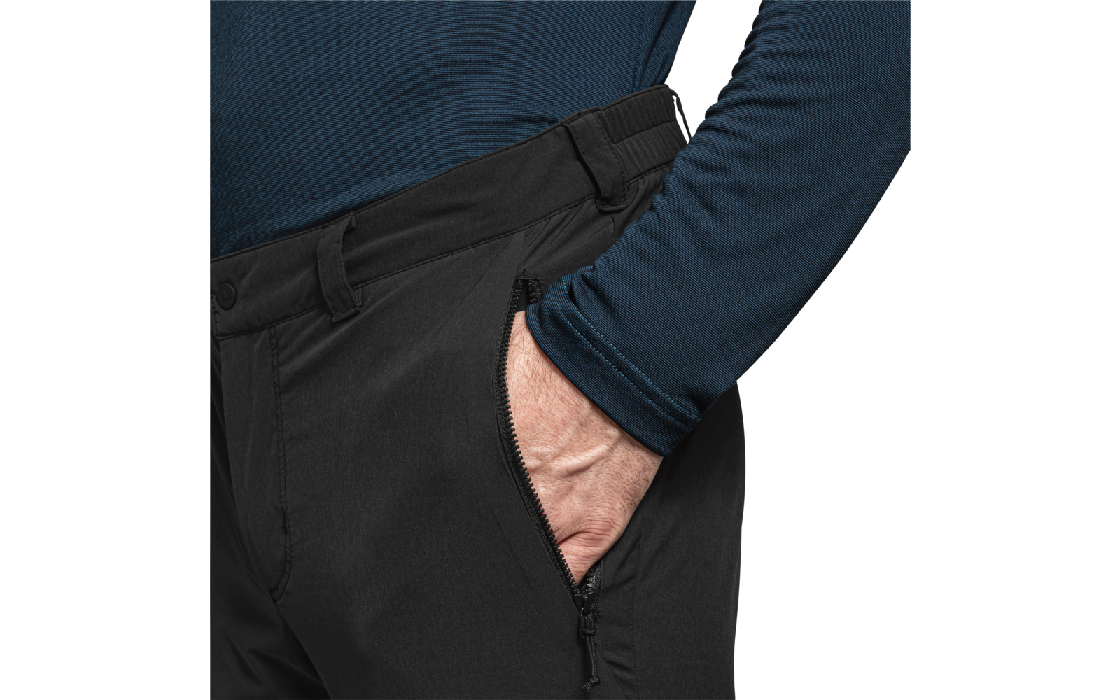 Bovenlichaam van een persoon met een donkerblauw shirt met lange mouwen, hand in de ritszak van een zwarte broek