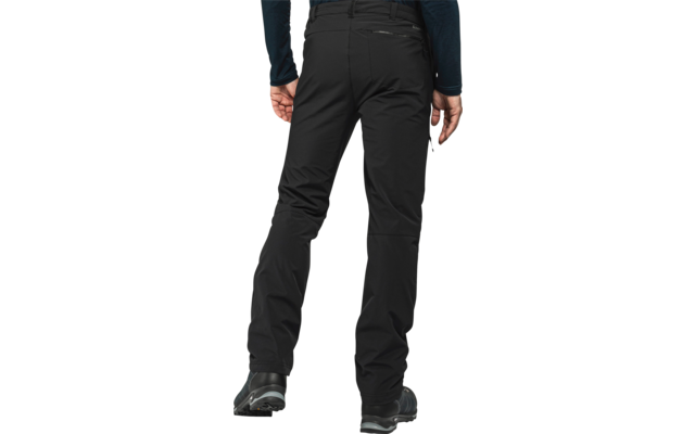 Achteraanzicht van een persoon van taille tot voeten, zwarte outdoorbroek, zwarte enkelschoenen, een hand langs het lichaam zichtbaar