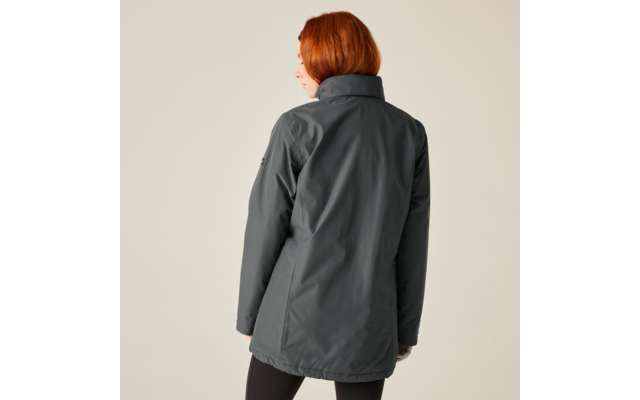 Personne aux cheveux roux portant une veste grise regardant vers la droite, avec un fond clair