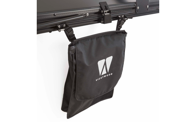 Schwarze Stofftasche mit Klappe und weißem VICKYWOOD-Logo, hängend an zwei schwarzen Clips an einer Metallstange vor weißem Hintergrund