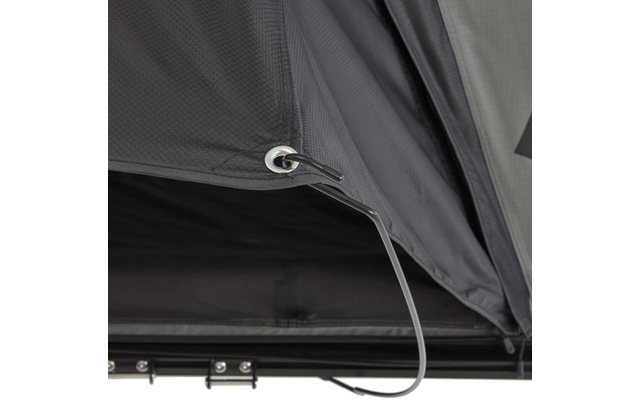 Nahaufnahme grauer, strukturierter Stoffpaneele mit offenem Reißverschluss, Metallöse, durchgezogenem schwarzem Band, dunklem Innenraum und Metallbeschlägen am unteren Rand