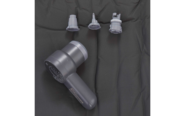 Graues Handgerät mit zylindrischem Kopf und drei separaten grauen Aufsätzen auf dunklem Stoff