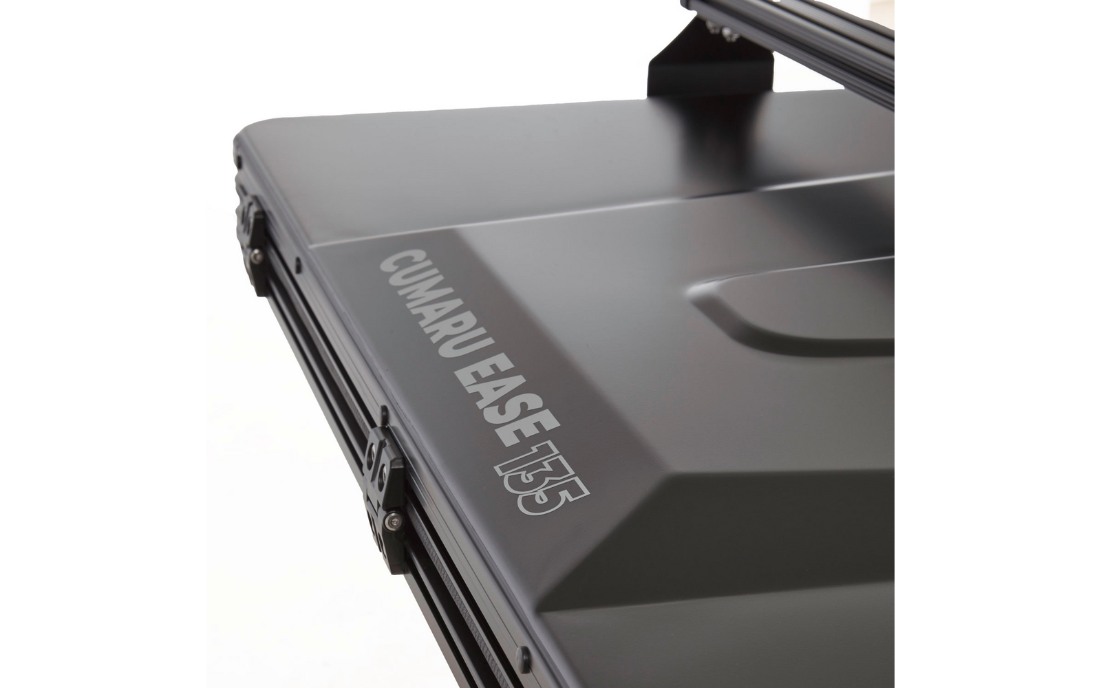 Gros plan d'un coffre de toit gris foncé avec l'inscription CUMARU EASE 135 et une attache métallique visible