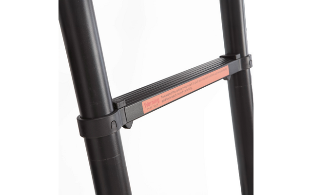 Gros plan d'une échelle télescopique noire montrant deux montants verticaux et un barreau déployé avec un autocollant d'avertissement orange sur fond blanc
