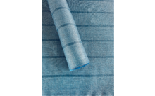 Rouleau de tissu bleu à carreaux sur un tissu bleu étalé