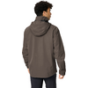 Mann von hinten, trägt graubraune Kapuzenjacke und dunkle Hose, Kopf nach rechts gedreht, lockiges dunkles Haar sichtbar