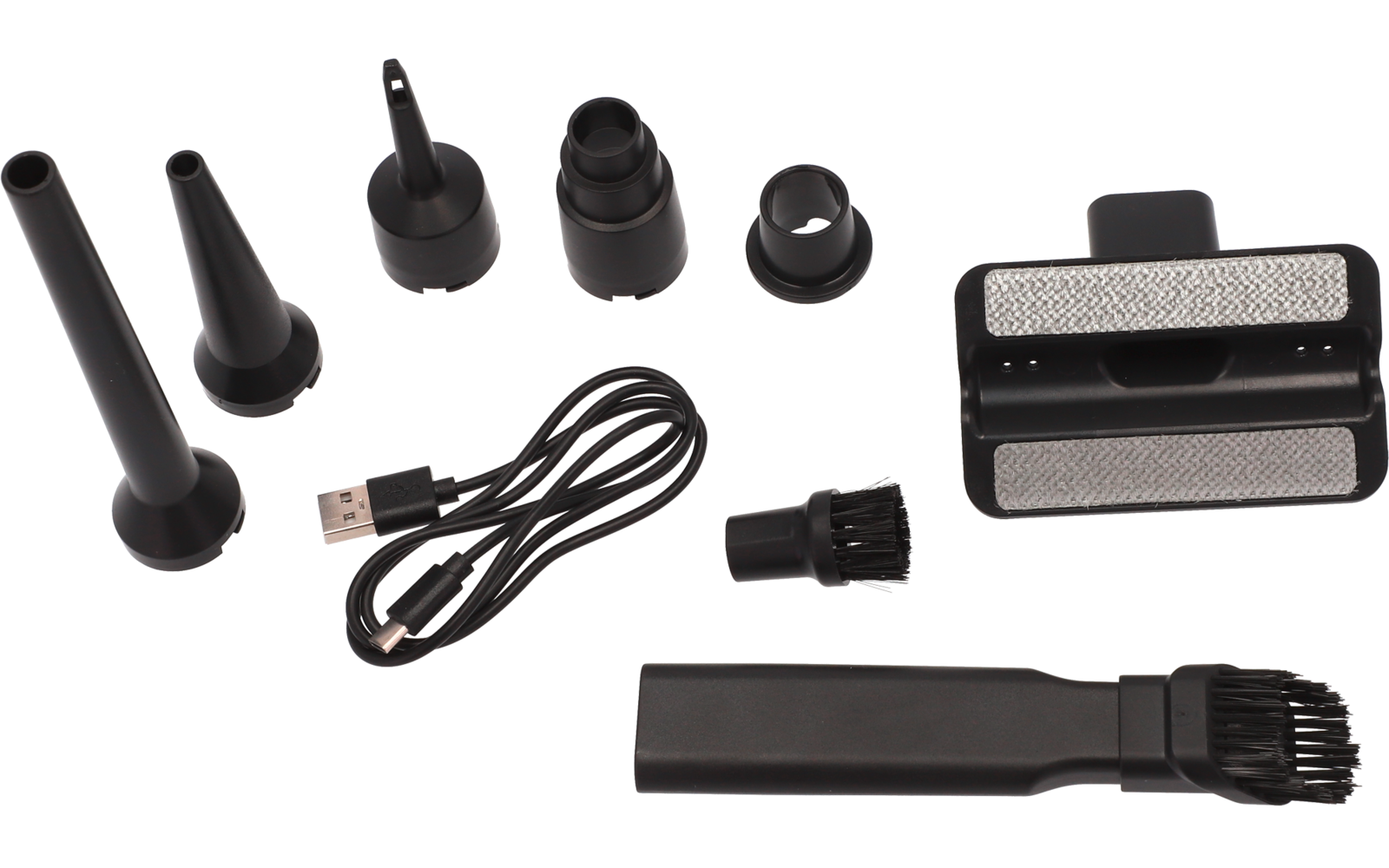Plusieurs embouts noirs coniques et cylindriques, un câble USB noir, une petite brosse à poils, une pièce rectangulaire avec deux surfaces métalliques en maille et un long embout plat avec extrémité brosse