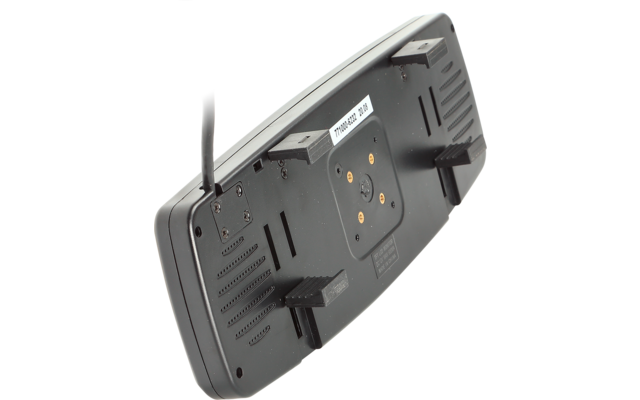 Rückseite eines rechteckigen schwarzen Geräts mit vier rechteckigen Halterungen, zentralem rundem Montagebereich mit vier goldenen Kontaktpunkten, weißem Aufkleber mit Text und seitlich herausführendem Kabel