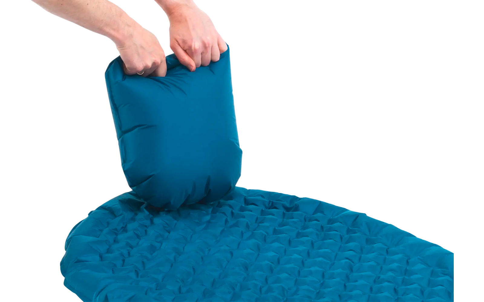 Hand legt een blauw opblaasbaar kussen op een blauw luchtbed