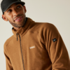 Mann trägt braune Jacke und schwarze Kappe, schaut nach links
