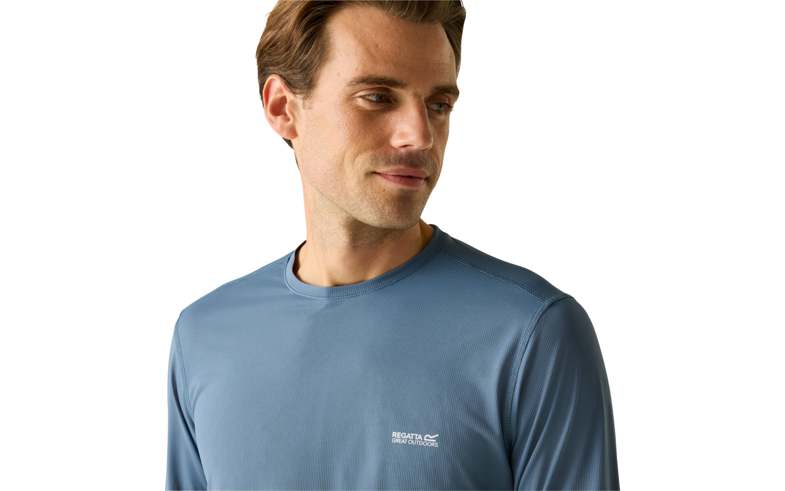 Porträt eines Mannes, der nach rechts schaut, trägt ein blaues langärmliges Shirt mit kleinem weißen Logo auf der Brust vor hellem Hintergrund