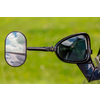 Rückspiegel und Sonnenbrille an einem Fahrzeug vor grünem Hintergrund