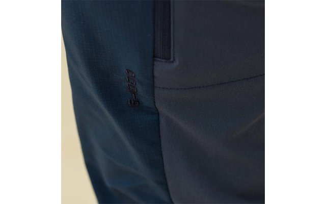 Nahaufnahme eines dunkelblauen Hosenstoffs mit seitlicher Naht, Eingrifftasche und kleinem dunklem eingesticktem Schriftzug