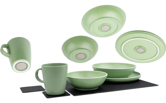 Grünes Geschirr-Set mit Tassen, Schalen und Tellern auf schwarzem Untergrund
