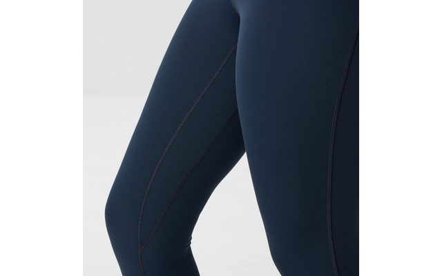 Primer plano de piernas con mallas deportivas azul marino oscuro con costuras visibles sobre fondo claro