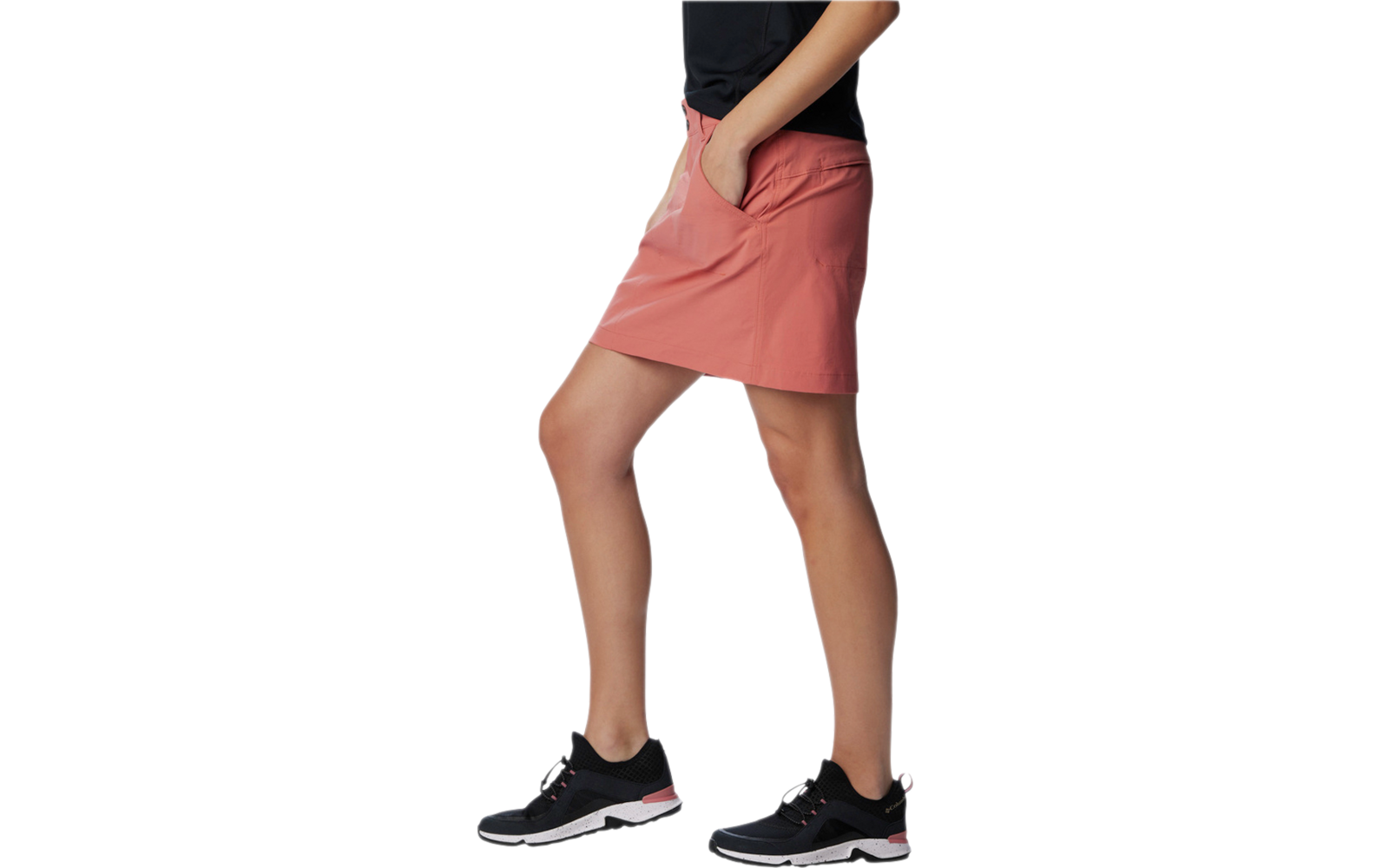 Mujer con falda corta roja y zapatillas deportivas negras, solo visibles las piernas