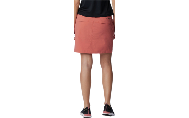 Vista trasera de una mujer con una falda roja y zapatos negros