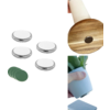 Fünf runde silberne Scheiben; drei runde grüne Scheiben; rundes Holzstück mit Loch und hellem Griff; Hand hält kleinen weißen Blumentopf mit grünen Blättern; quadratisches weißes Tuch
